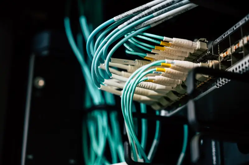 Fiber patch cables routed into a network switch inside a dark equipment rack